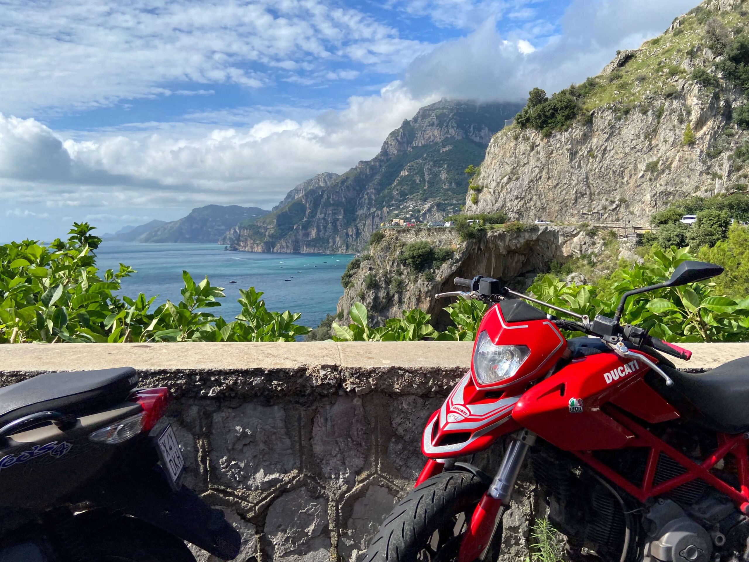 Motorbike and Scooter parked up with the Amalfi Coastline behind them.