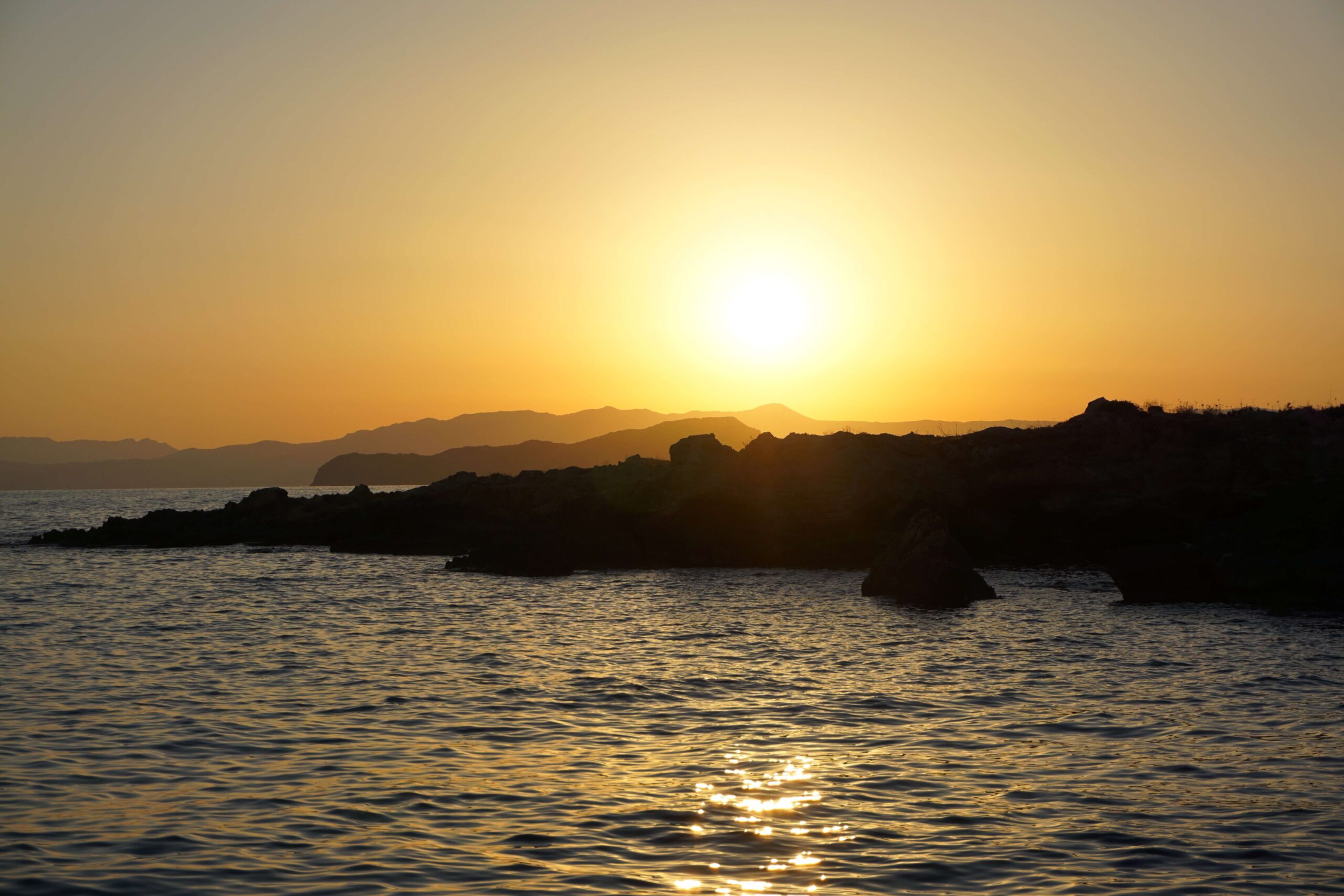 Sun setting over the Kissamos Mountains from the boat